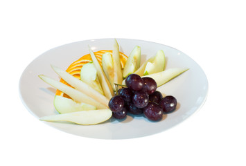 Fruit cut from pears, apples, oranges and grapes on a white plate. Pickled ginger and wasabi. on white background