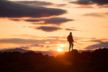 Fototapeta na wymiar silhouette of a man on a rock at sunset, iceland