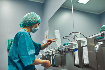 The doctor washes his hands before surgery. Sterility concept. A professional surgeon washes his...