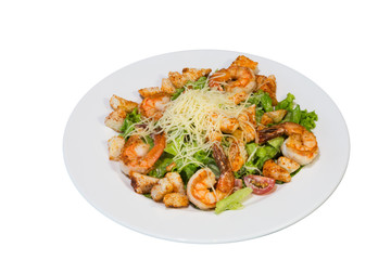 Salad with fried large prawns with herbs and crackers on a white plate. on white background