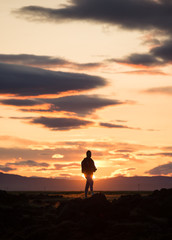 silhouette of a man on a rock at sunset, iceland