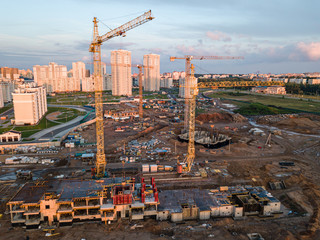 Aerial view of construction site of residential area buildings with cranes