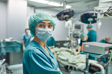 Portrait of a female surgeon, operation in the background. Surgery medicine concept. Female surgeon, gender equality, saving lives. beauty and health