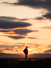 Fototapeta na wymiar silhouette of a man on a rock at sunset, iceland