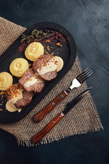 Delicious tender pork chop with mashed potatoes, traditional Italian cuisine. Food photo, wood background. Low key. Top view of copy space
