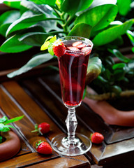 a glass of strawberry cocktail garnished with strawberry __