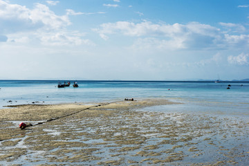 Ko Phi Phi island outflow. Vacations in Thailand scenic view. Low water level wet sand background. Sea boats floating landscape.