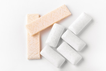 Chewing gum top view macro photography on a white background. A lot of gum is scattered on the table.