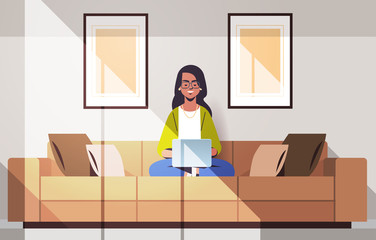 beautiful indian woman sitting on couch using laptop girl working from home freelance concept modern living room interior horizontal full length vector illustration