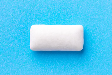 Obraz premium Chewing gum in the shape of a pillow on a blue background, top view.