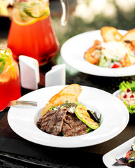 a plate with marinated beef salad served with bread toast