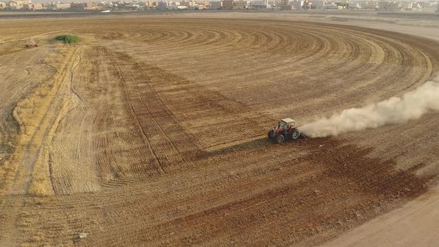 Syria, latakia province. Aerial view of a tractor processing a round field