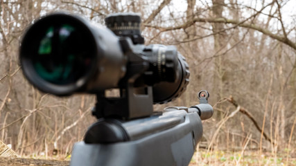 rifle with scope on the background of the forest
