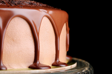 caramel drip on cake closeup. mousse caramel cake with caramel topping and grated chocolate closeup. dessert isolated on black