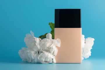 Liquid foundation cream bottle and cherry blossoms flowers. Beauty and cosmetology branding,...