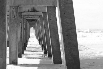 under the Naples pier in black and white