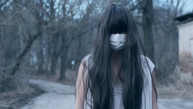 ghost of dead girl in bactericidal mask on her face is protected from corona virus.