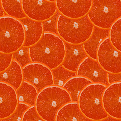 Seamless pattern of exotic fruits: grapefruit slices. Wallpaper with a pattern of slices of juicy...