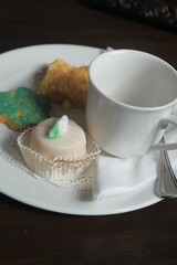 white coffee cup, white plate, cookie, cupcake, 