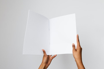 Woman of color holding a blank letter-sized or A4 mockup.