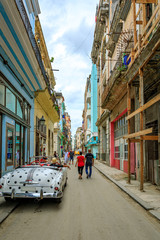 Havana Cuba An oldtimer vintage car driving  in a colorful facade street.