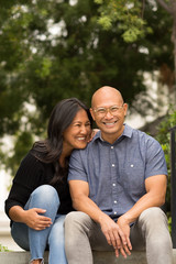 Fototapeta premium Happy Asian couple smiling and hugging outside.