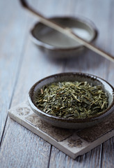 Fototapeta na wymiar Dried Green Tea Leaves on Bright Background. Close up. 