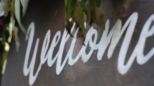 Welcom to our beginning. Maridge, frame.welcome sign on it decorated with flowers outdoor.
