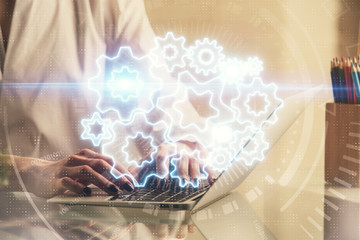 Double exposure of woman hands typing on computer and business theme hologram drawing. Success...