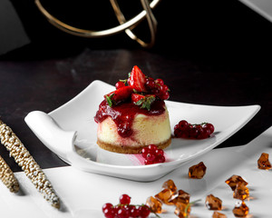 portioned cheesecake topped with berries and jam