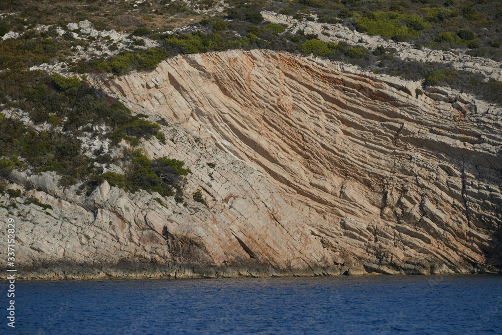 Wall mural beautiful high cliff with caves and hanging rocks of a mountain in adriatic sea, a crevice, colorful