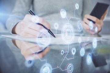 Double exposure of technology sketch hologram and woman holding and using a mobile device.