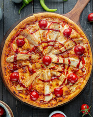 top view of chicken pizza with red bell pepper tomato cheese and ketchup