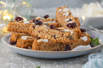Fototapeta na wymiar Granola bar. Healthy snack. Cereal granola bar with nuts, fruit, coconut and cranberries on a christmas table