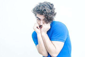 Helpless guilty guy covering lower face with hands. Handsome bearded young man in blue casual t-shirt posing isolated over white background. Victim concept