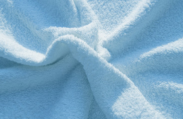 Blue fluffy Terry towel, a simple example of the texture of a soft, fleecy fabric, a background of...