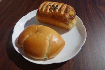 白い皿の上のクリームパンとさつまいもデニッシュ