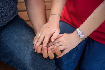 Female palm in male palm on grass background. People are next to each other.