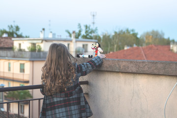 cute little girl is playing with a romanian traditional doll