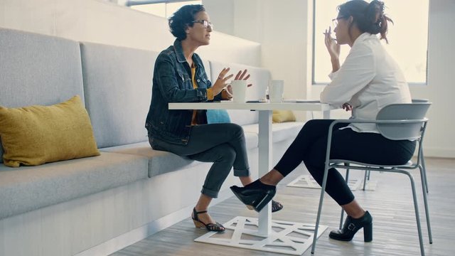 Manager having a one-on-one session with an employee in the office. Two women sitting at the table and having a business interview.
