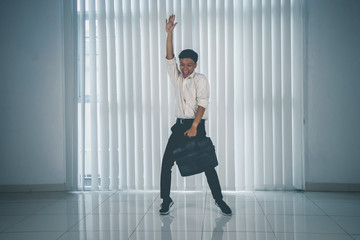 Fototapeta na wymiar Cheerful man dancing with suit and briefcase