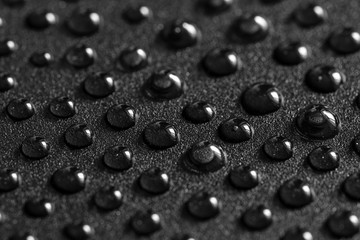 Water drops on black metal surface. 