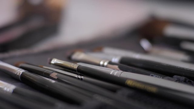 Professional makeup brushes in a make-up kit close up chenging focus Brush, Comb, Eye Shadow in a leather bag