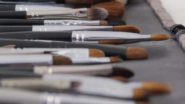 Professional makeup brushes in a make-up kit close up chenging focus Brush, Comb, Eye Shadow in a leather bag