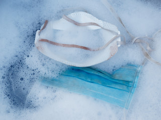 Close-up of washing disposable medical face mask with washing powder. Deficiency of personal care product during the epidemic coronavirus.