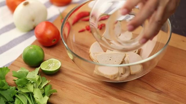 The cook makes Spicy Vietnamese Sausage Salad.
