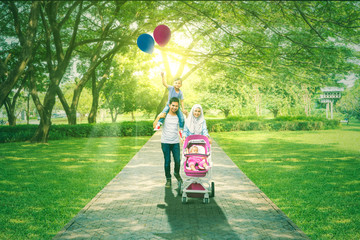 Cute children and parents walking in the park