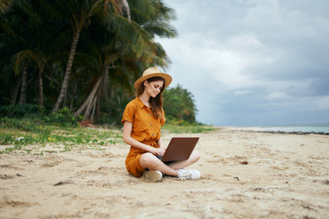 woman with laptop on the beach