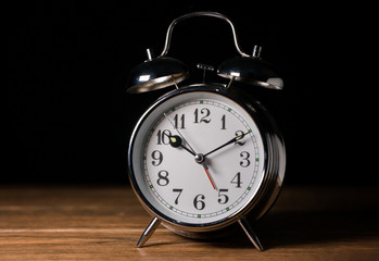 viejo y antiguo reloj despertador metálico en una tabla de madera