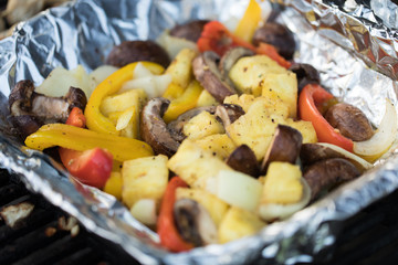 Close up of veggies cooking in foil on grill